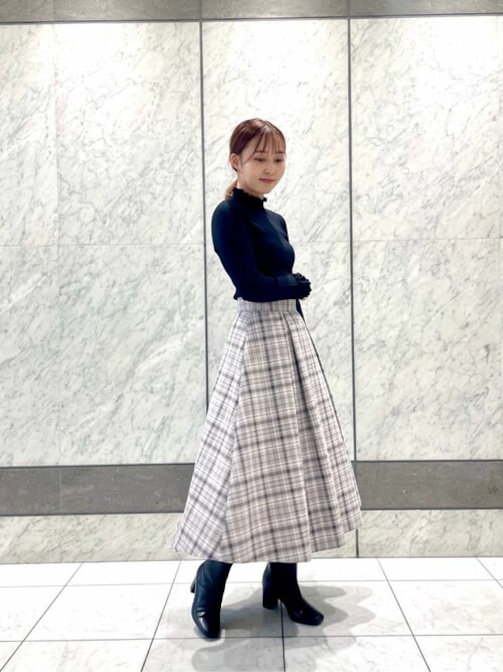 ブラック系のニット/セーター、グレー系のスカートを着用したレディースの秋コーディネートの1枚目の写真