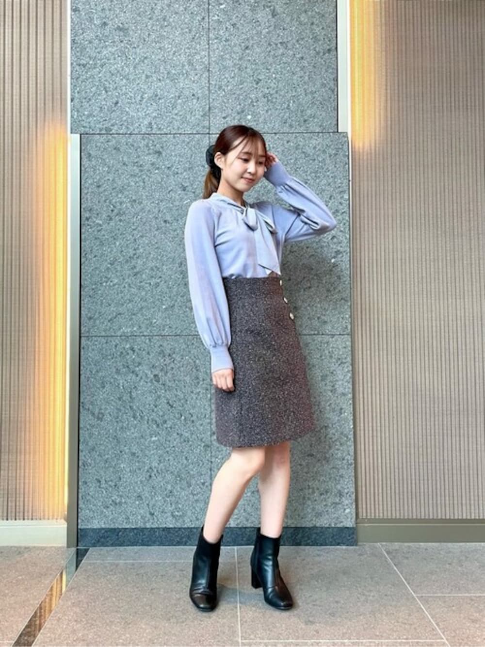 ブルー系のニット/セーター、グレー系のスカートを着用したレディースの秋コーディネートの1枚目の写真