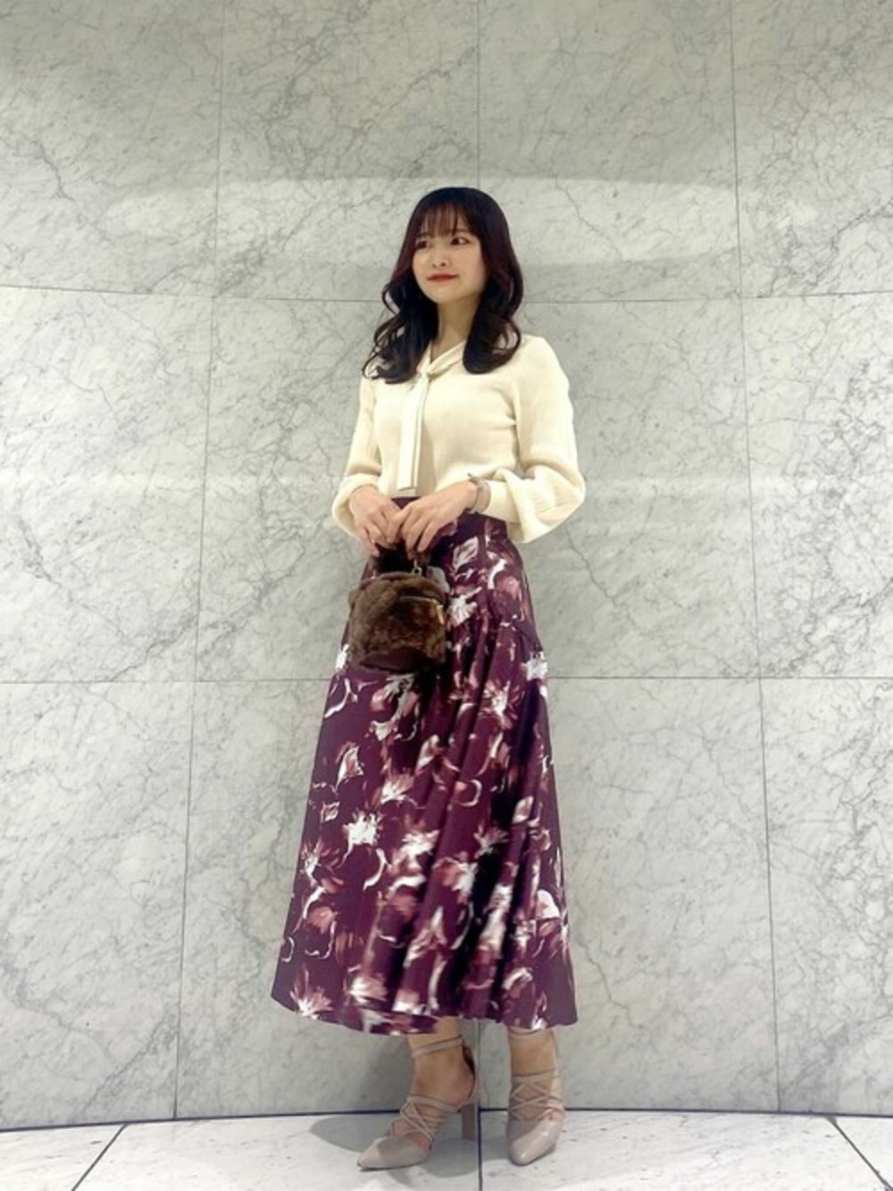 ホワイト系のニット/セーター、レッド系のスカート、ブラウン系のショルダーバッグを着用したレディースの秋コーディネートの1枚目の写真