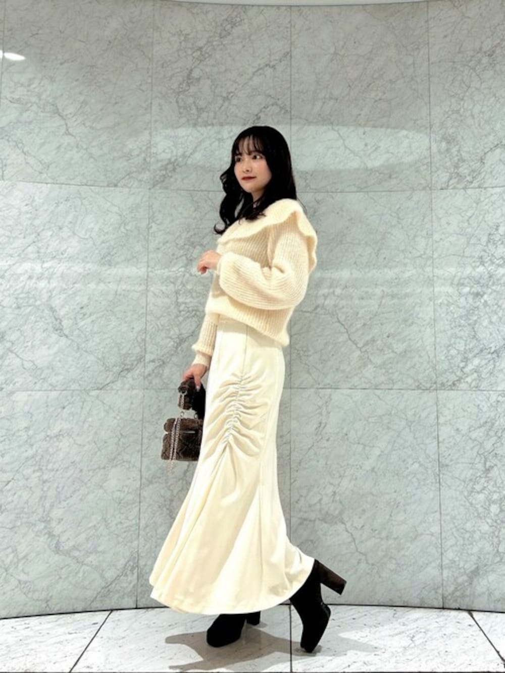 ベージュ系のニット/セーター、ホワイト系のスカート、ブラウン系のショルダーバッグを着用したレディースの冬コーディネートの1枚目の写真