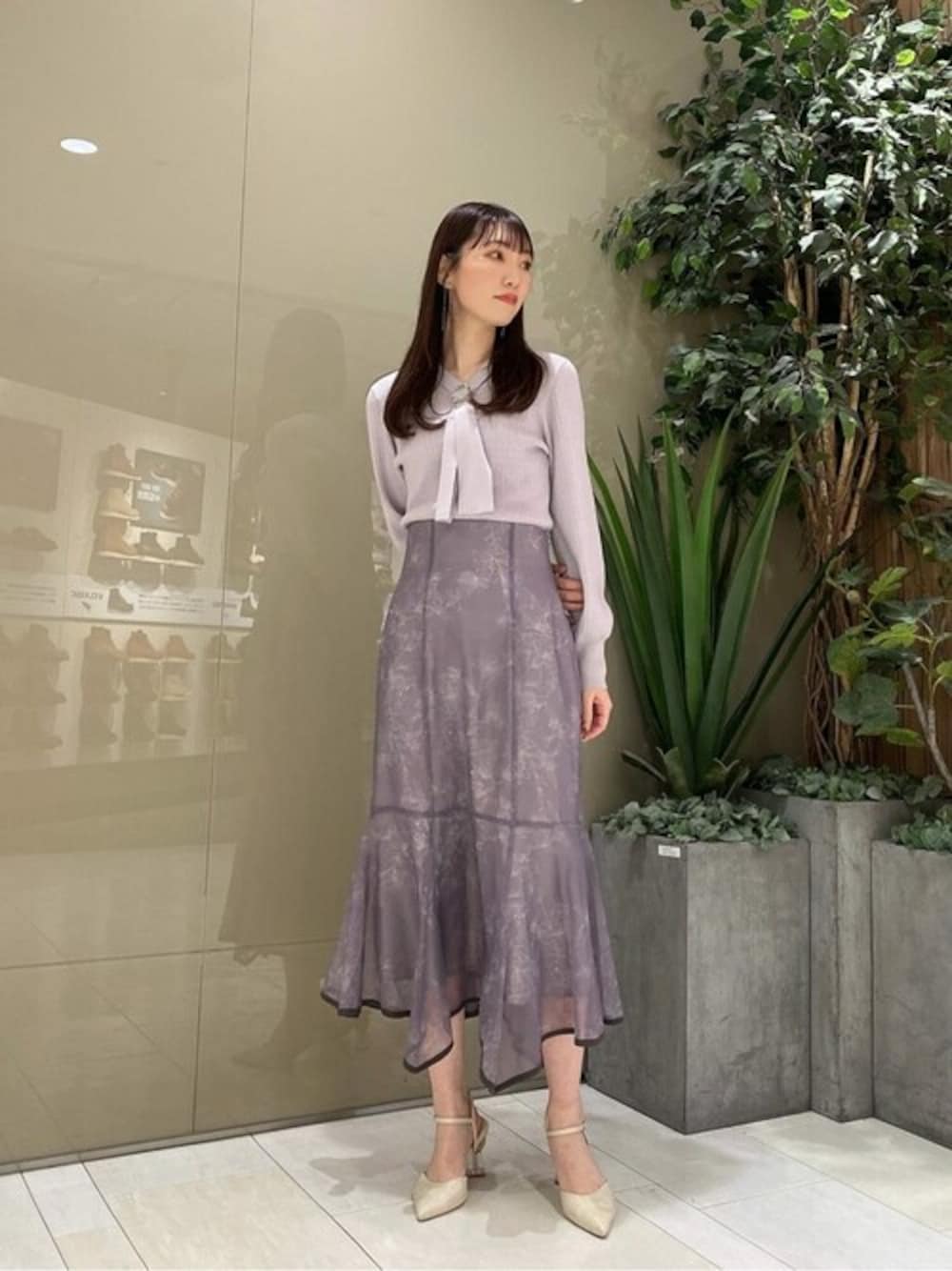 グレー系のニット/セーター、グレー系のスカートを着用したレディースの冬コーディネートの1枚目の写真