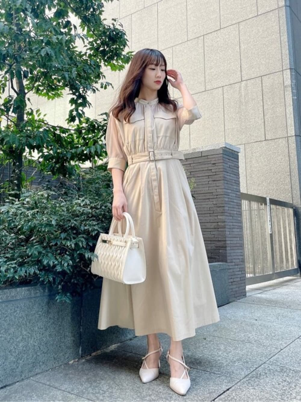 ベージュ系のワンピース、ホワイト系のショルダーバッグを着用したレディースの春コーディネートの1枚目の写真