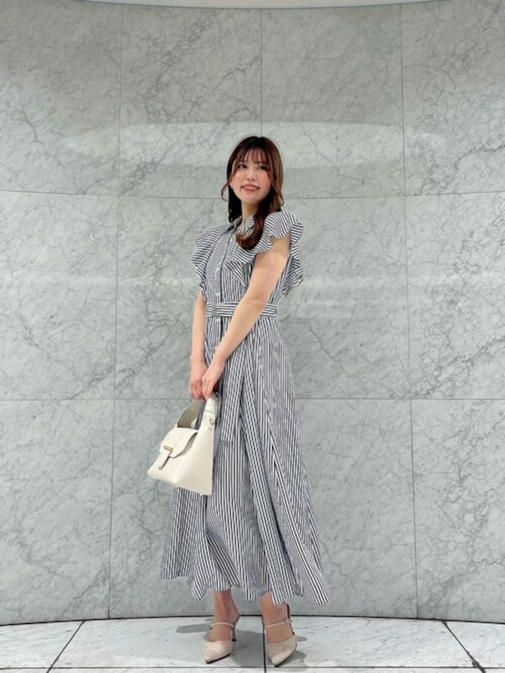 ブルー系のワンピース、ホワイト系のトートバッグを着用したレディースの春コーディネートの1枚目の写真