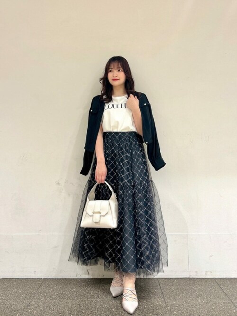 ホワイト系のTシャツ/カットソー、ブラック系のスカート、ブラック系のブルゾンを着用したレディースの春コーディネートの1枚目の写真