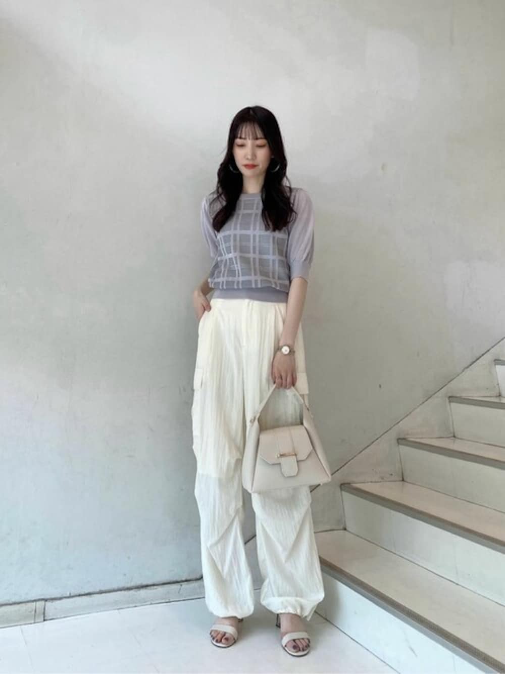 グレー系のニット/セーター、ホワイト系のその他パンツ、ホワイト系のトートバッグを着用したレディースの春コーディネートの1枚目の写真