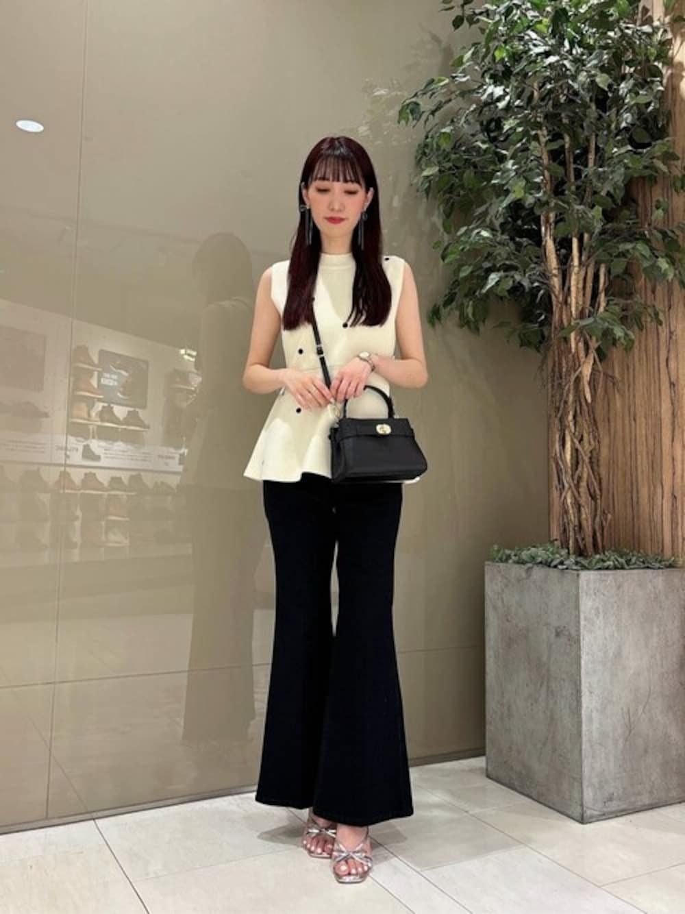 ホワイト系のニット/セーター、ブラック系のデニムパンツを着用したレディースの夏コーディネートの1枚目の写真