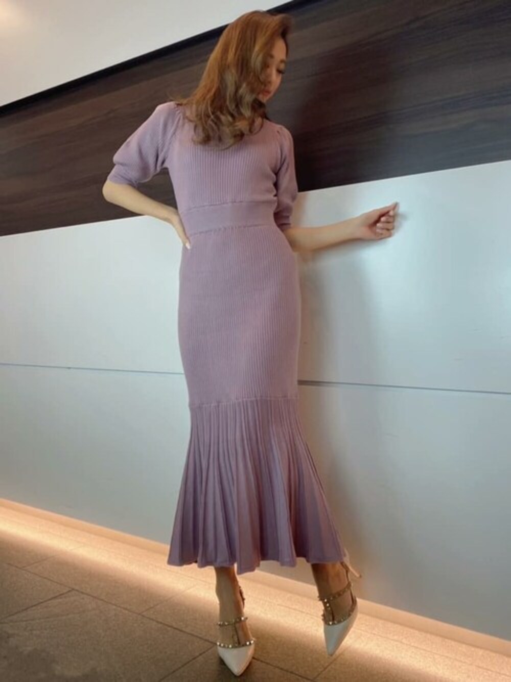 パープル系のワンピース、ホワイト系のパンプスを着用したレディースの冬コーディネートの1枚目の写真