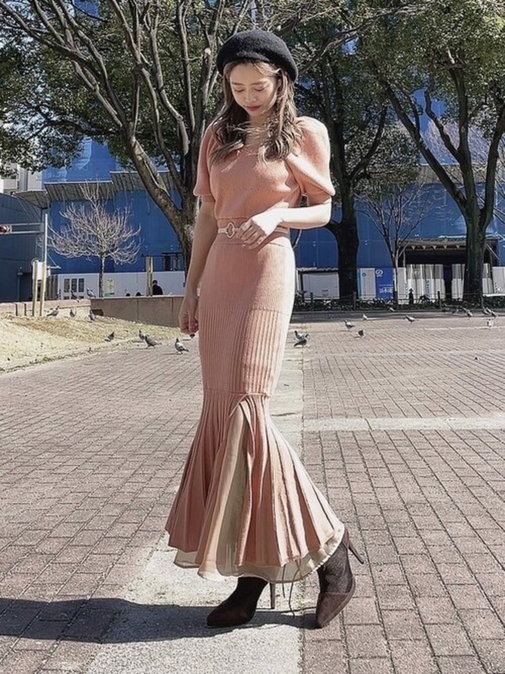 オレンジ系のワンピース、ブラウン系のブーツ、ブラック系のハンチング/ベレー帽を着用したレディースの春コーディネートの1枚目の写真