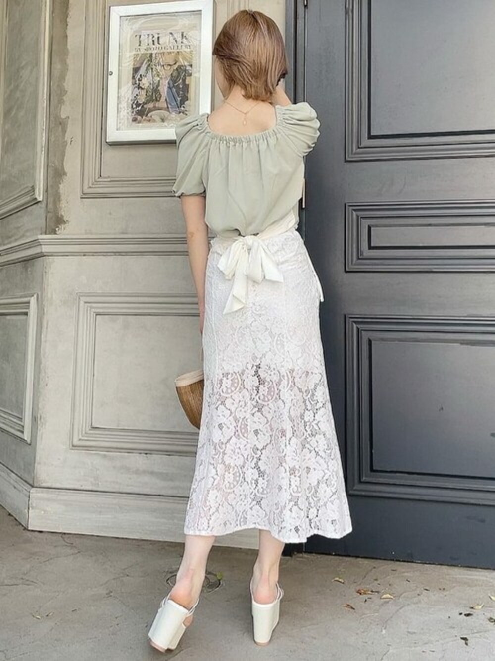 グリーン系のシャツ/ブラウス、ホワイト系のサンダル、ベージュ系のハンドバッグを着用したレディースの春コーディネートの1枚目の写真