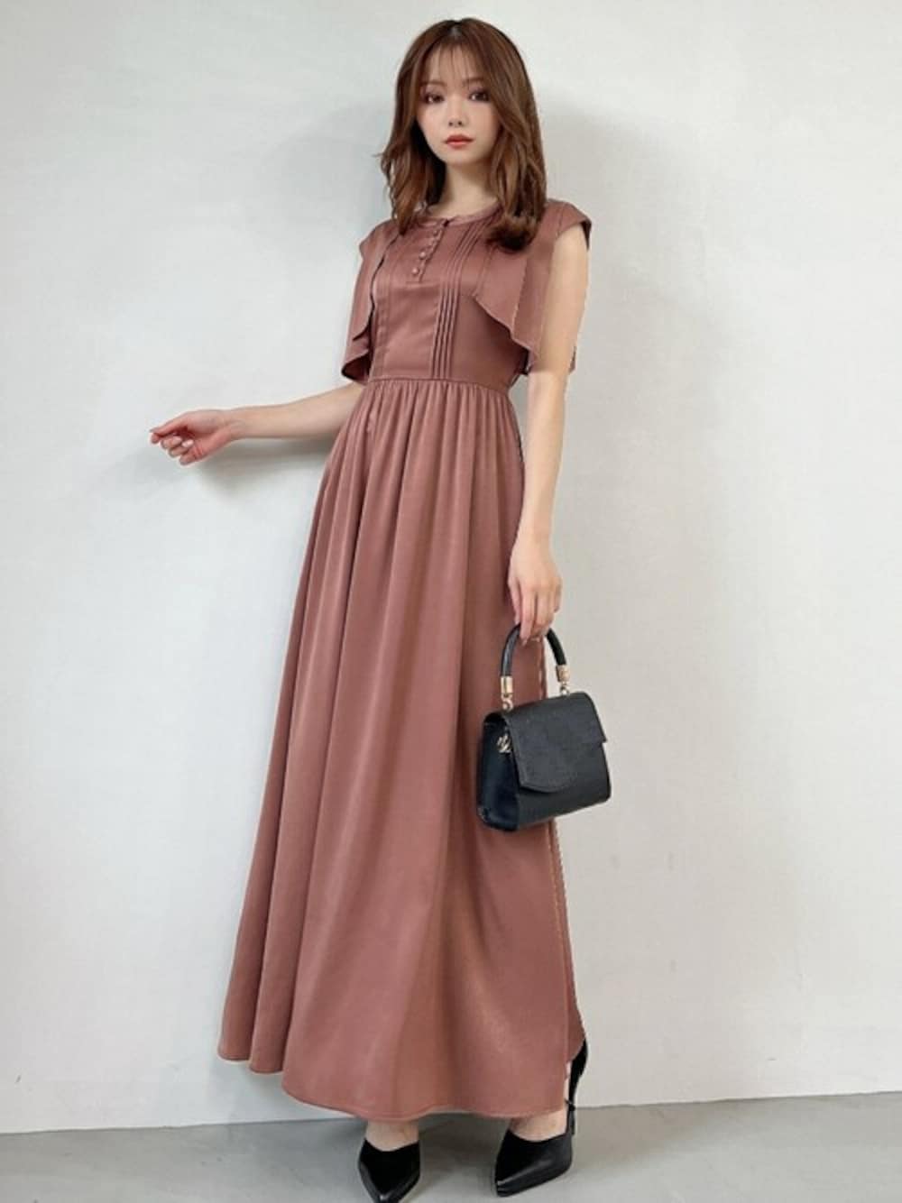 ブラウン系のドレス、ブラック系のパンプスを着用したレディースの秋コーディネートの1枚目の写真