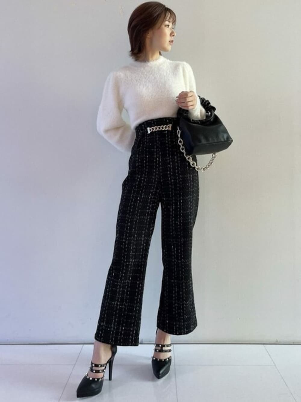 ホワイト系のニット/セーター、ブラック系のその他パンツ、ブラック系のハンドバッグを着用したレディースの秋コーディネートの1枚目の写真