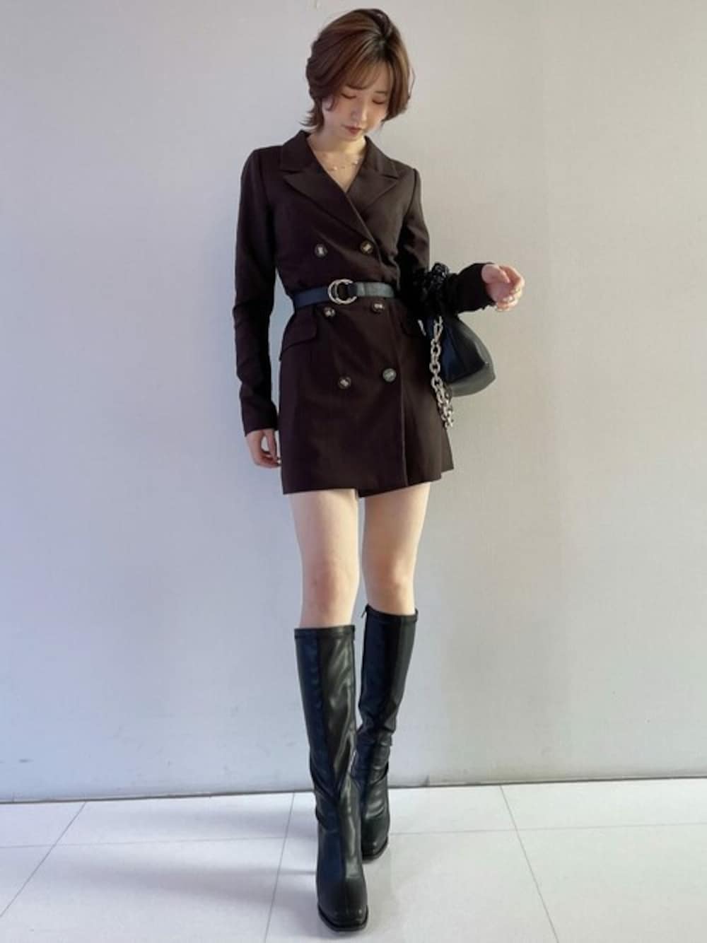 ブラウン系のワンピース、ブラック系のハンドバッグ、ブラック系のブーツを着用したレディースの秋コーディネートの1枚目の写真