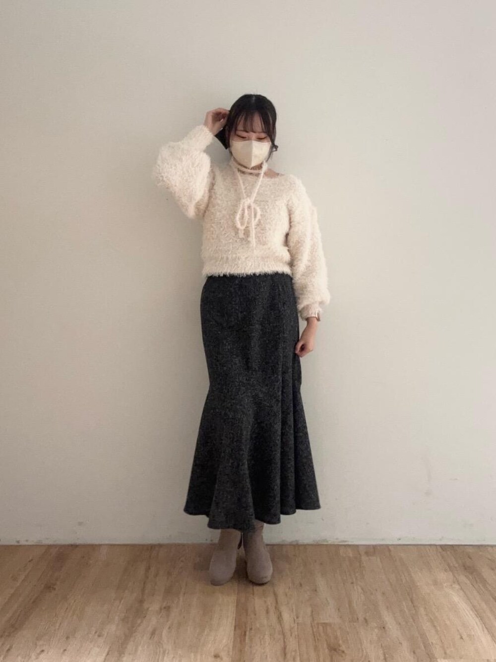 ベージュ系のブーツ、ピンク系のニット/セーター、ブラック系のスカートを着用したレディースの冬コーディネートの1枚目の写真