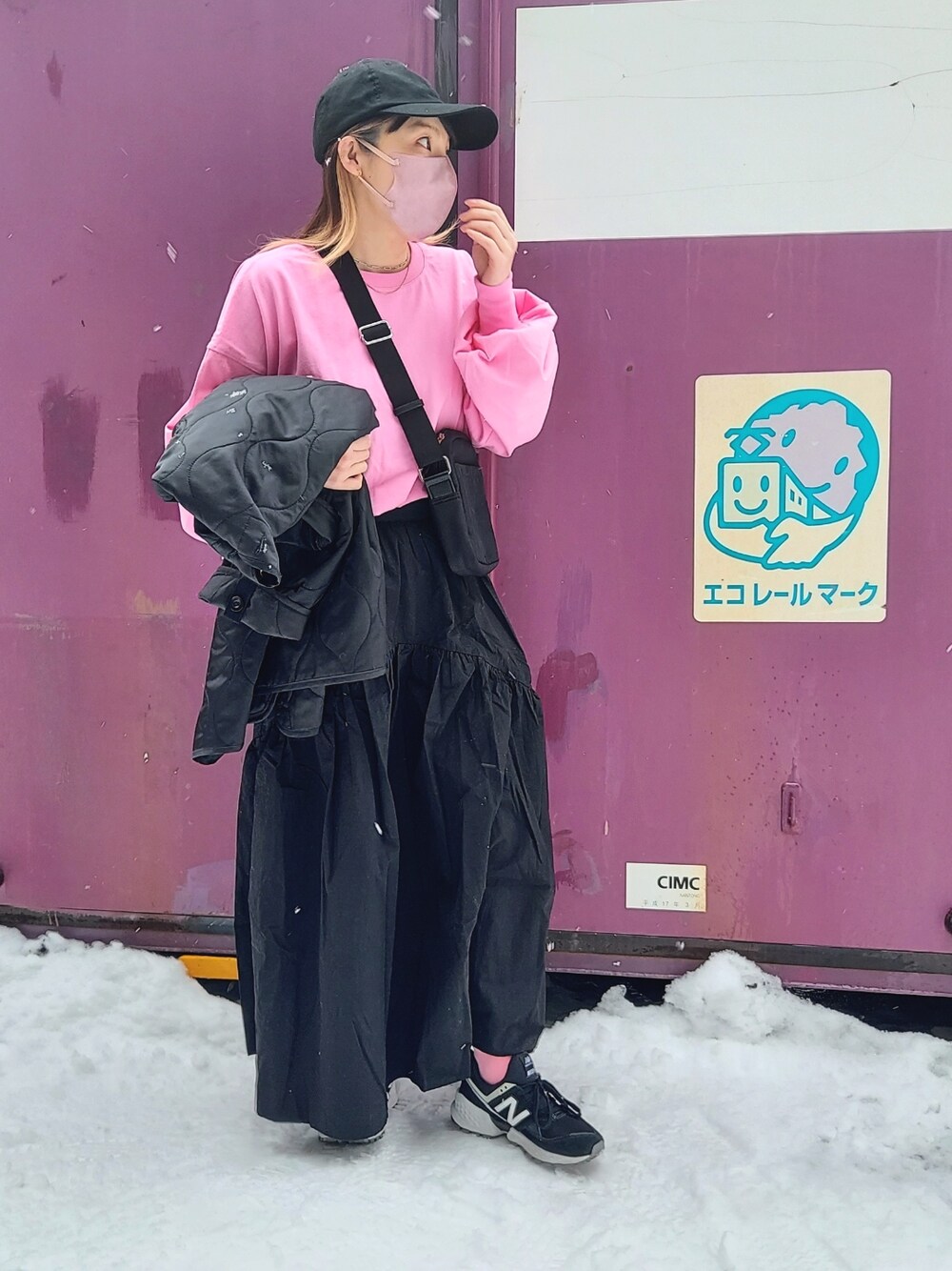 ピンク系のTシャツ/カットソー、ブラック系のスカート、ブラック系のショルダーバッグを着用したレディースの冬コーディネートの1枚目の写真