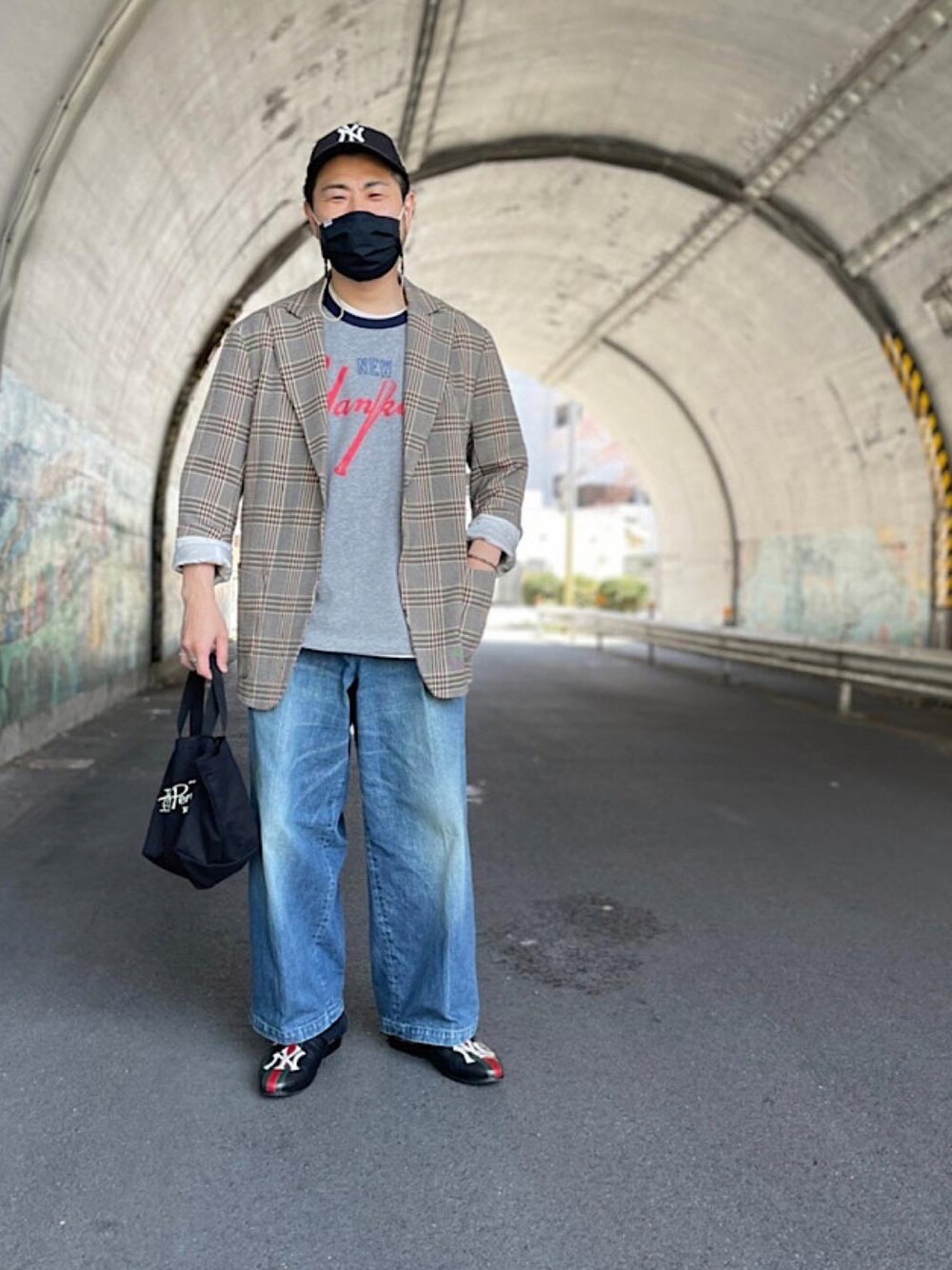 ブラック系のトートバッグ、ブラック系のシューズ、ブルー系のその他パンツを着用したメンズの春コーディネートの1枚目の写真