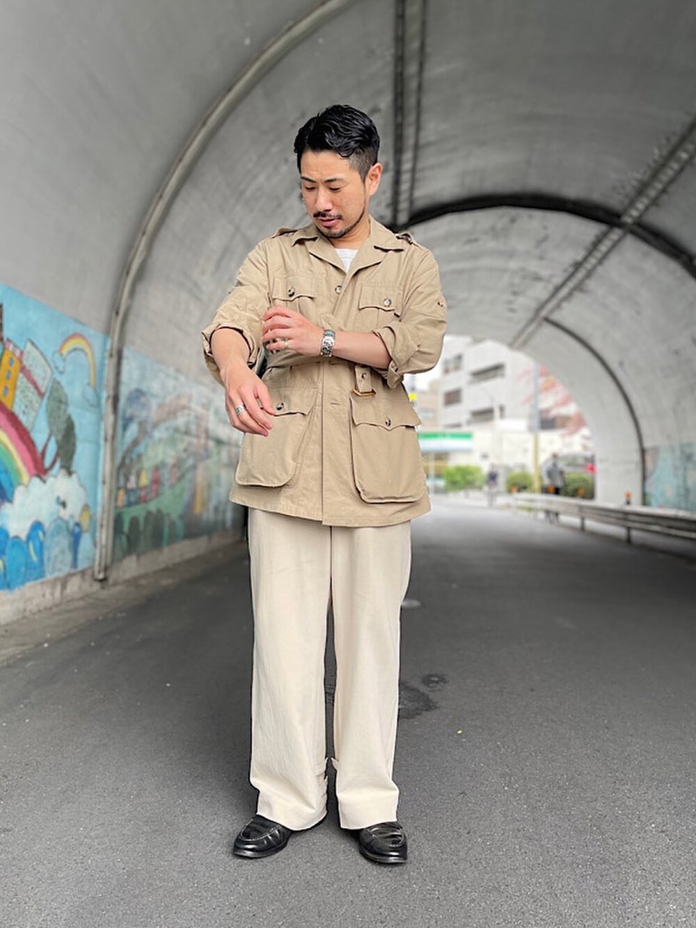 ベージュ系のその他パンツ、ブラック系のシューズ、ベージュ系のミリタリージャケットを着用したメンズの春コーディネートの1枚目の写真