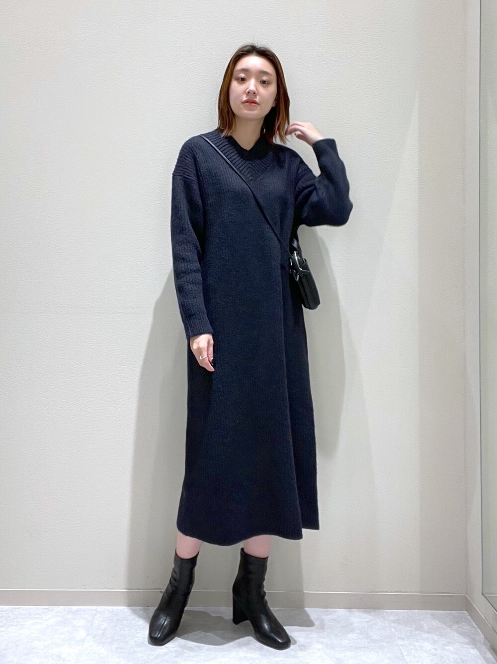 ブルー系のワンピース、ブラック系のショルダーバッグ、ブラック系のブーツを着用したレディースの秋コーディネートの1枚目の写真