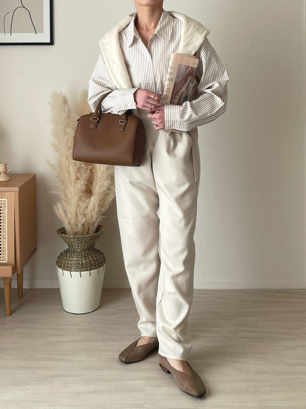 ブラウン系のバッグ、ベージュ系のシャツ/ブラウス、ホワイト系のパンツを着用したレディースの冬コーディネートの1枚目の写真