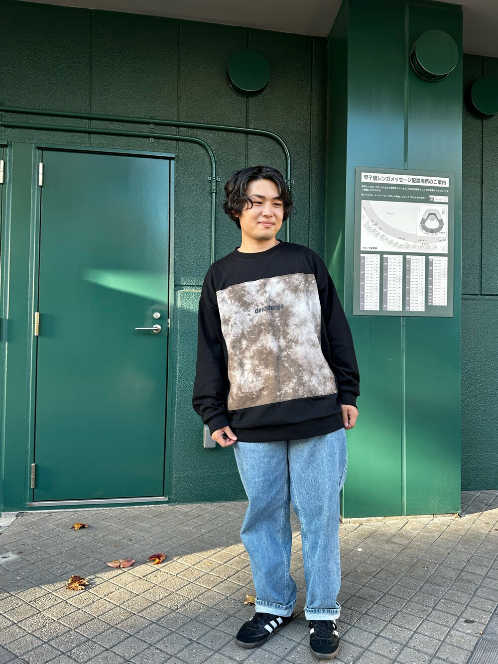 ブラック系のスニーカー、ブルー系のデニムパンツ、ブラック系のスウェットを着用したメンズの秋コーディネートの1枚目の写真