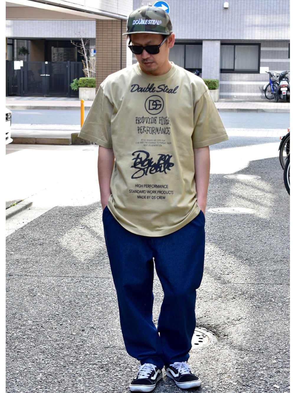 ブラック系のスニーカー、ブルー系のデニムパンツ、グリーン系のTシャツ/カットソーを着用したメンズの夏コーディネートの1枚目の写真