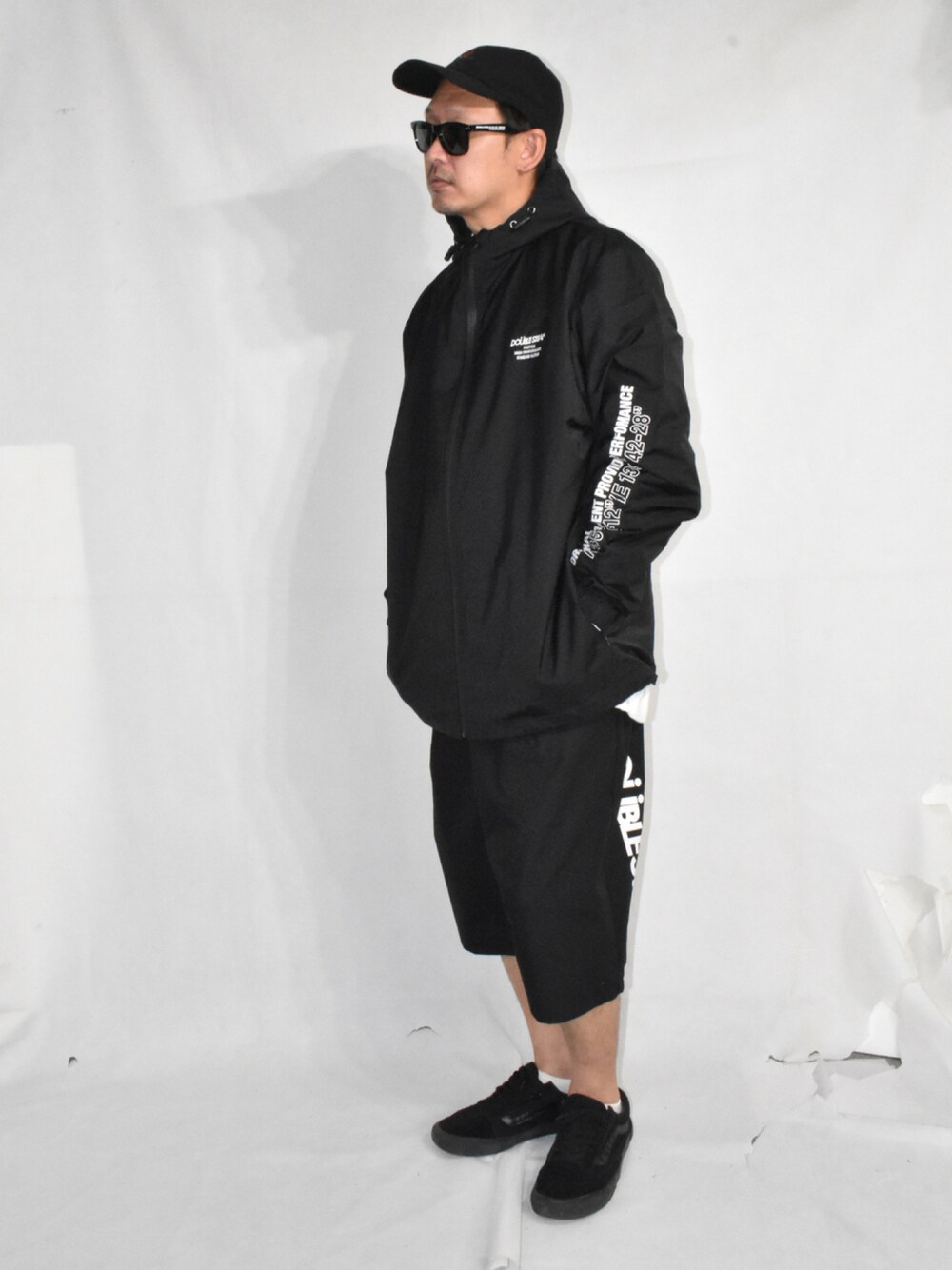 ブラック系のスニーカー、ブラック系のチノパンツ、ブラック系のマウンテンパーカーを着用したメンズの秋コーディネートの1枚目の写真