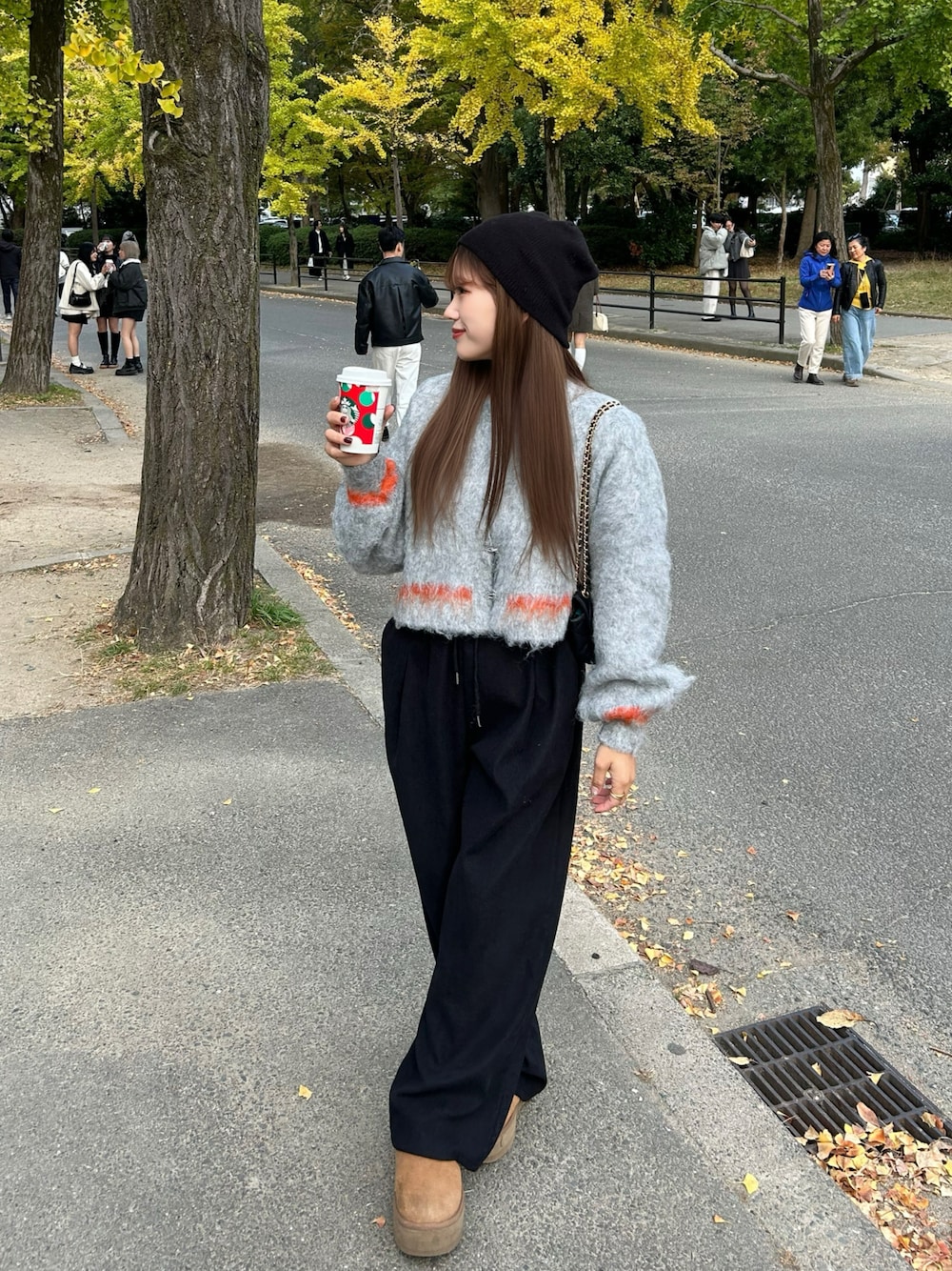 グレー系のニット/セーター、ブラウン系のブーツ、ブラック系のニットキャップ/ビーニーを着用したレディースの秋コーディネートの1枚目の写真