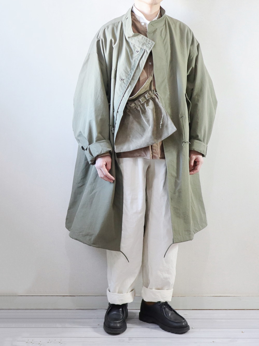 グリーン系のモッズコート、ブラウン系のシャツ/ブラウス、グリーン系のショルダーバッグを着用したメンズの冬コーディネートの1枚目の写真