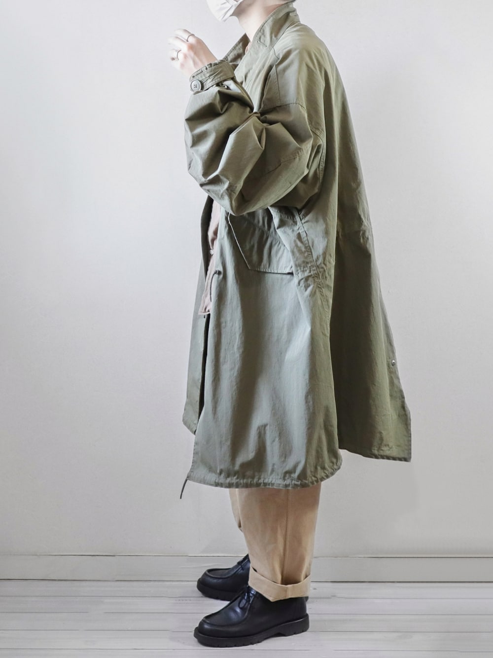 グリーン系のモッズコート、ブラウン系のシャツ/ブラウス、ベージュ系のチノパンツを着用したメンズの秋コーディネートの1枚目の写真