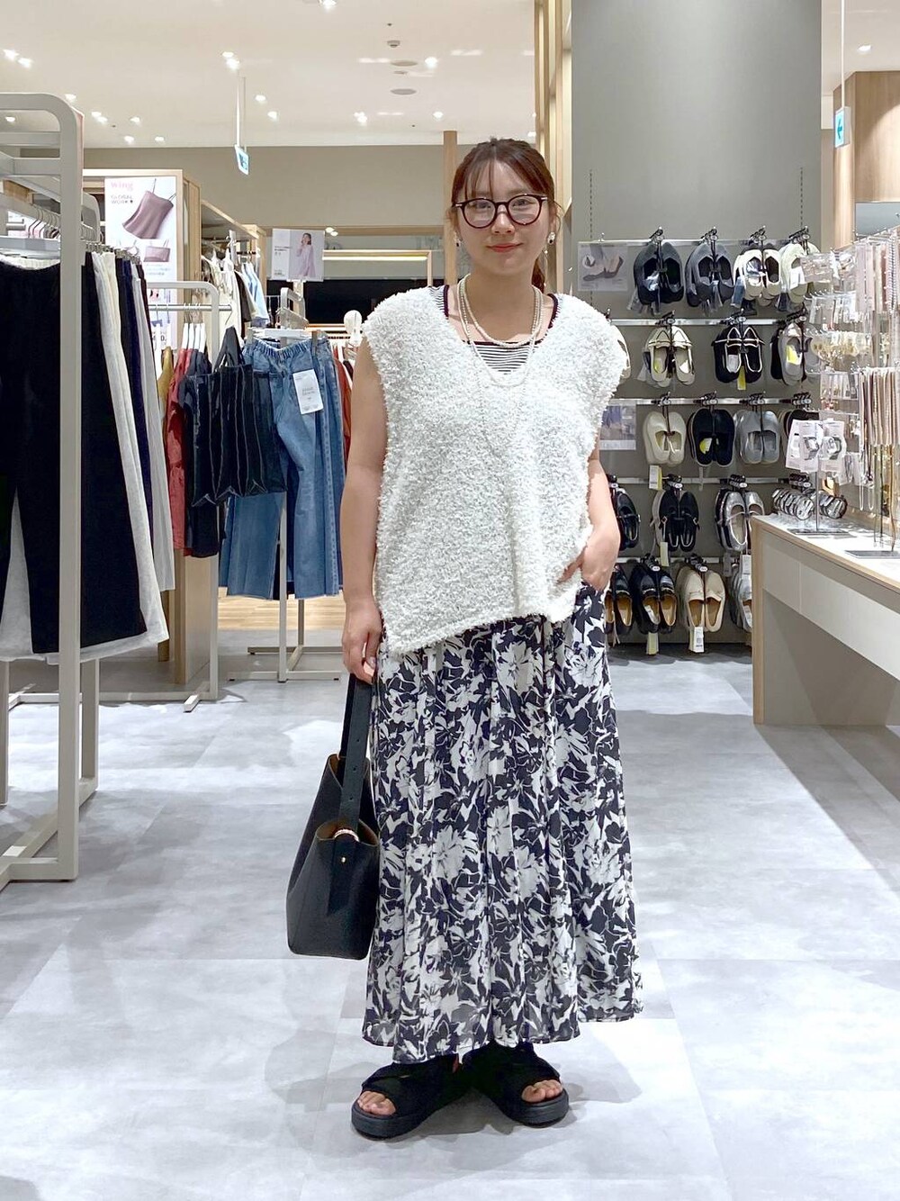 ブラック系のスカート、ブラック系のショルダーバッグ、その他のタンクトップを着用したレディースの夏コーディネートの1枚目の写真