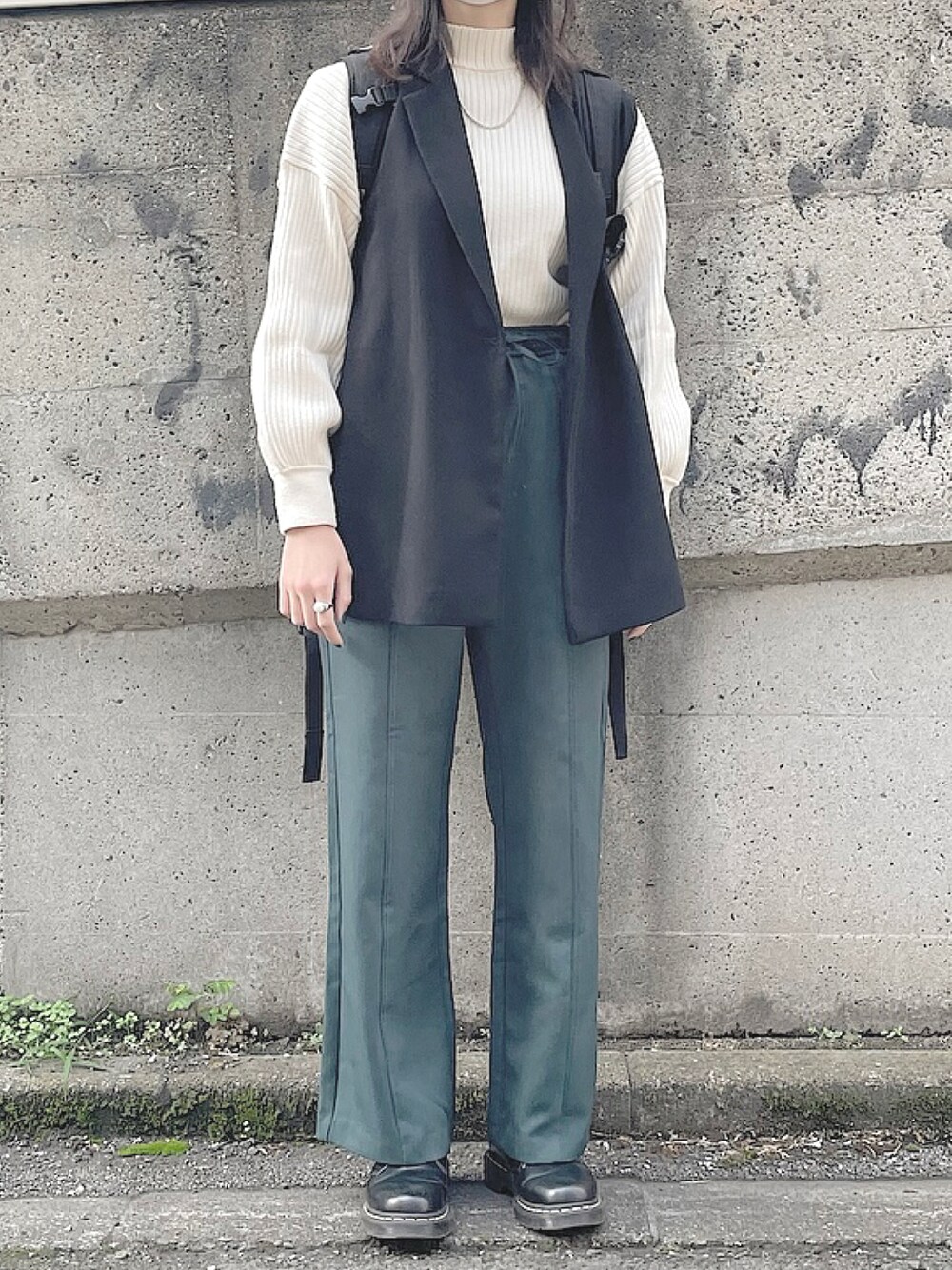 グリーン系のパンツ、ブラック系のドレスシューズ、ブラック系のジャケット/アウターを着用したレディースの秋コーディネートの1枚目の写真