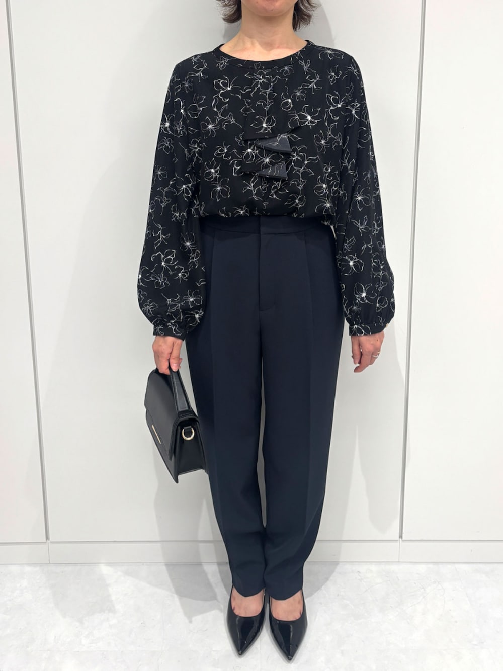 ブルー系のスラックス、ブラック系のシャツ/ブラウスを着用したレディースの冬コーディネートの1枚目の写真