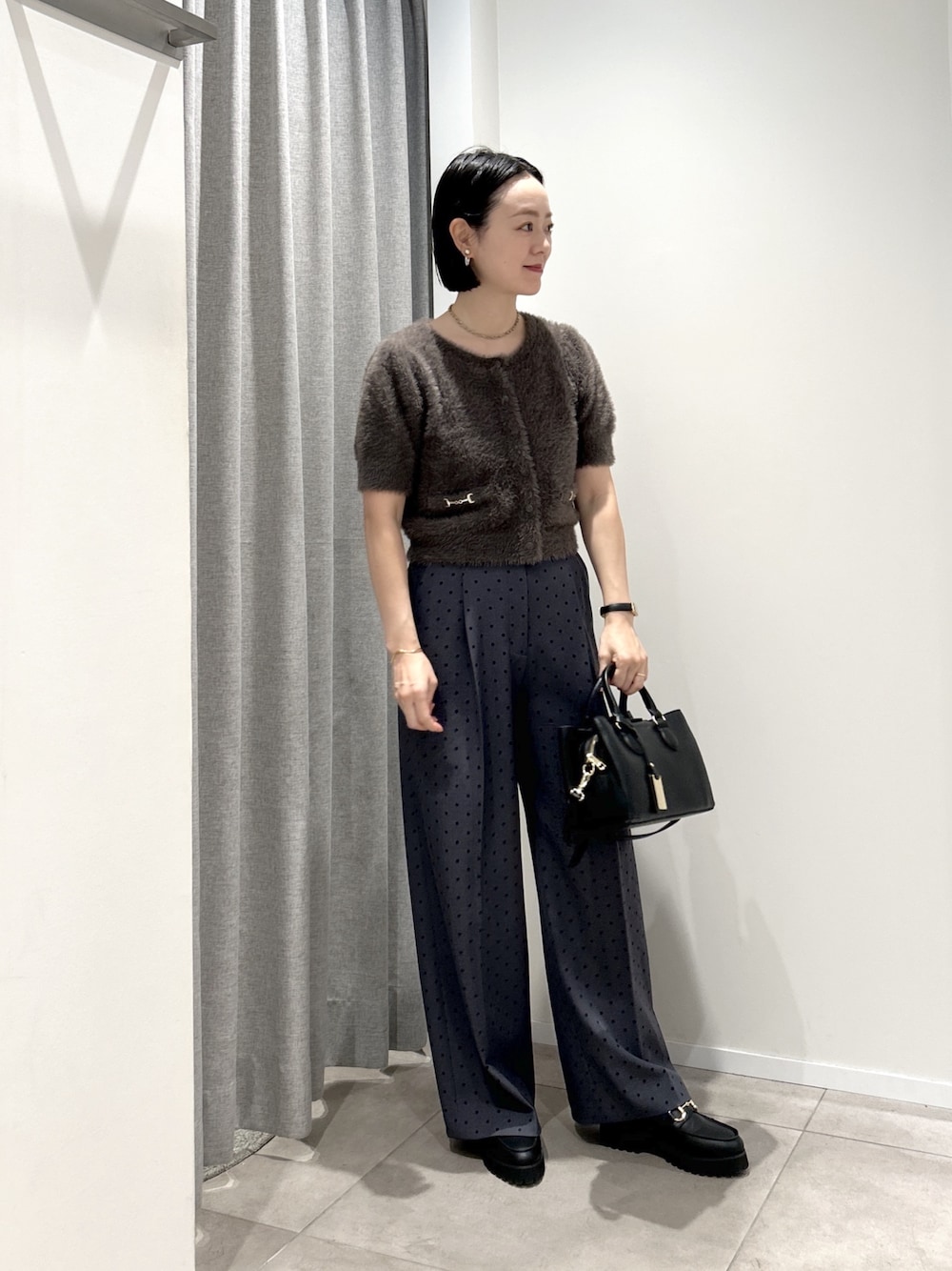 グレー系のその他パンツ、グレー系のニット/セーター、ブラック系のローファーを着用したレディースの夏コーディネートの1枚目の写真
