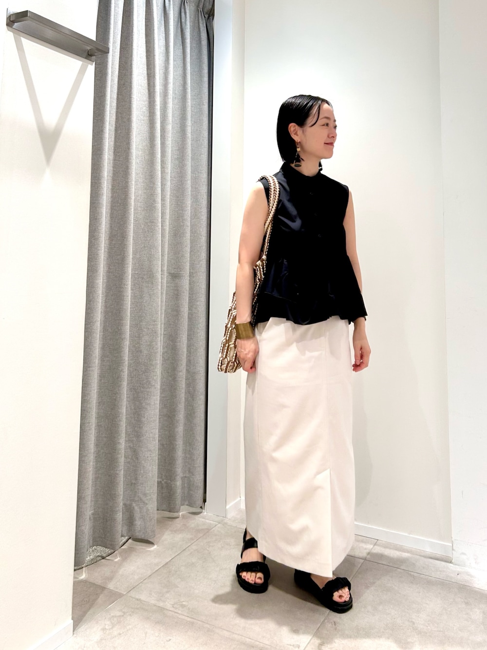 ブラック系のシャツ/ブラウス、ホワイト系のスカート、ブラウン系のトートバッグを着用したレディースの夏コーディネートの1枚目の写真