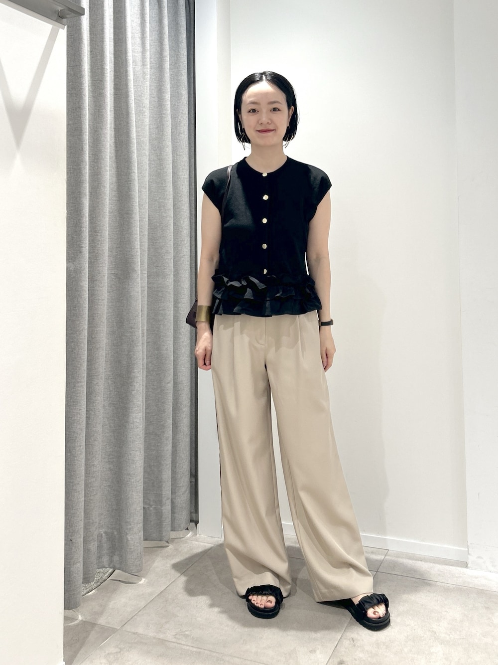 ベージュ系のその他パンツ、ブラック系のベストを着用したレディースの夏コーディネートの1枚目の写真