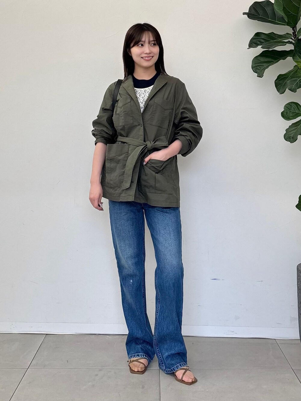 グリーン系のその他アウター、ブルー系のデニムパンツ、ホワイト系のTシャツ/カットソーを着用したレディースの春コーディネートの1枚目の写真