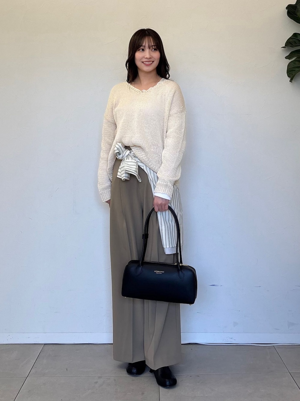 ベージュ系のスラックス、ベージュ系のシャツ/ブラウス、ホワイト系のTシャツ/カットソーを着用したレディースの春コーディネートの1枚目の写真