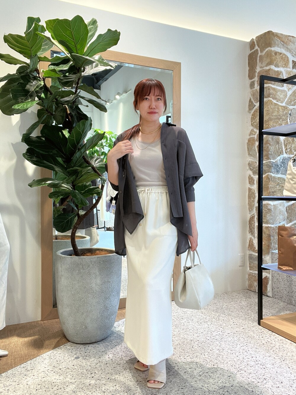 グレー系のタンクトップ、グレー系のシャツ/ブラウス、ホワイト系のトートバッグを着用したレディースの春コーディネートの1枚目の写真
