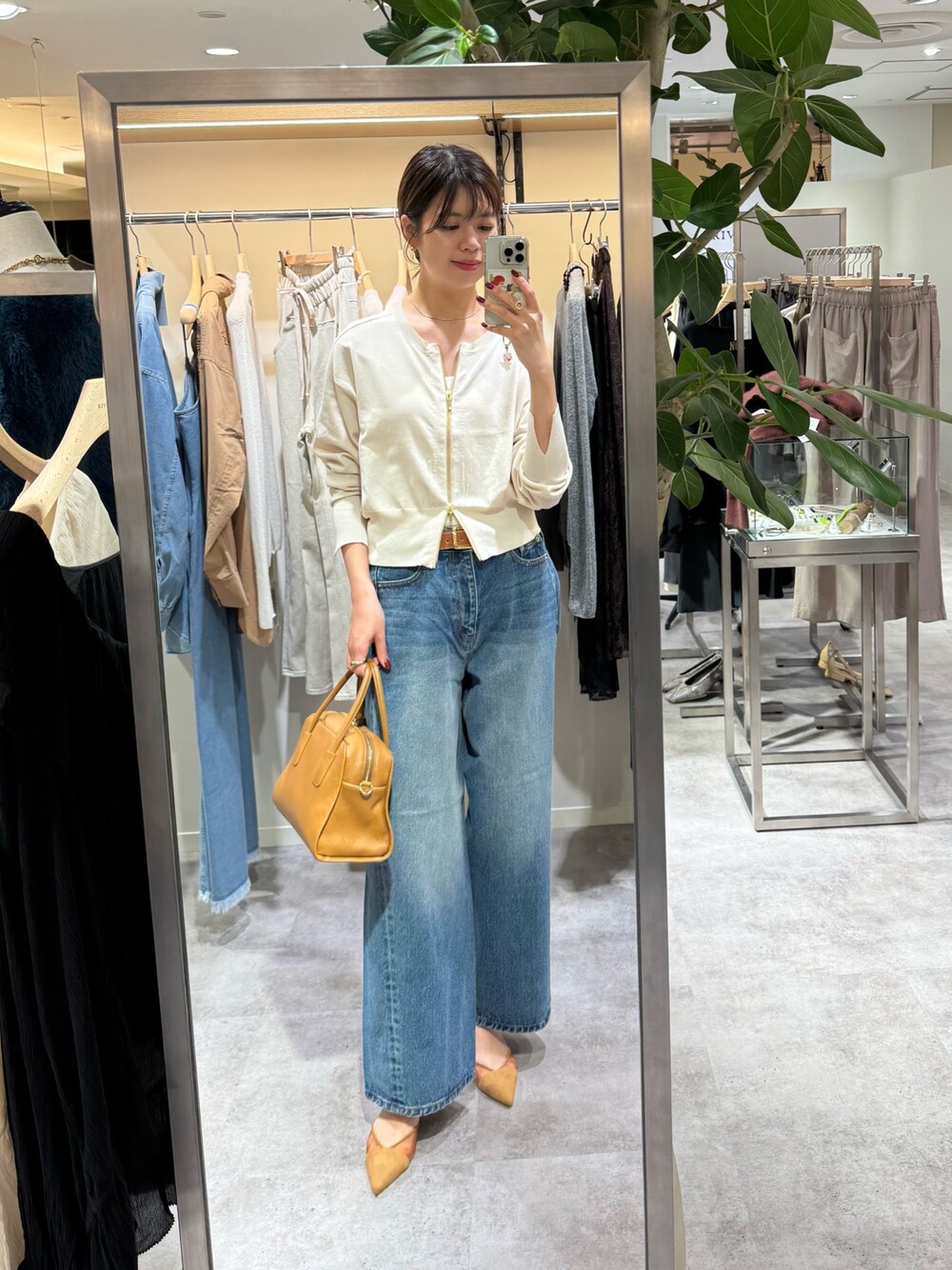 ブルー系のデニムパンツ、ホワイト系のカーディガン/ボレロ、ブラウン系のパンプスを着用したレディースの秋コーディネートの1枚目の写真