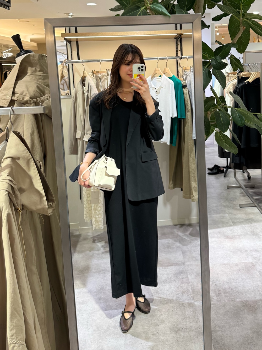 ブラック系のテーラードジャケット、ブラック系のワンピース、ホワイト系のショルダーバッグを着用したレディースの春コーディネートの1枚目の写真