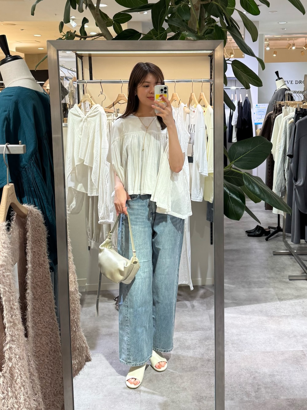 ブルー系のデニムパンツ、ホワイト系のシャツ/ブラウス、ゴールド系のショルダーバッグを着用したレディースの春コーディネートの1枚目の写真