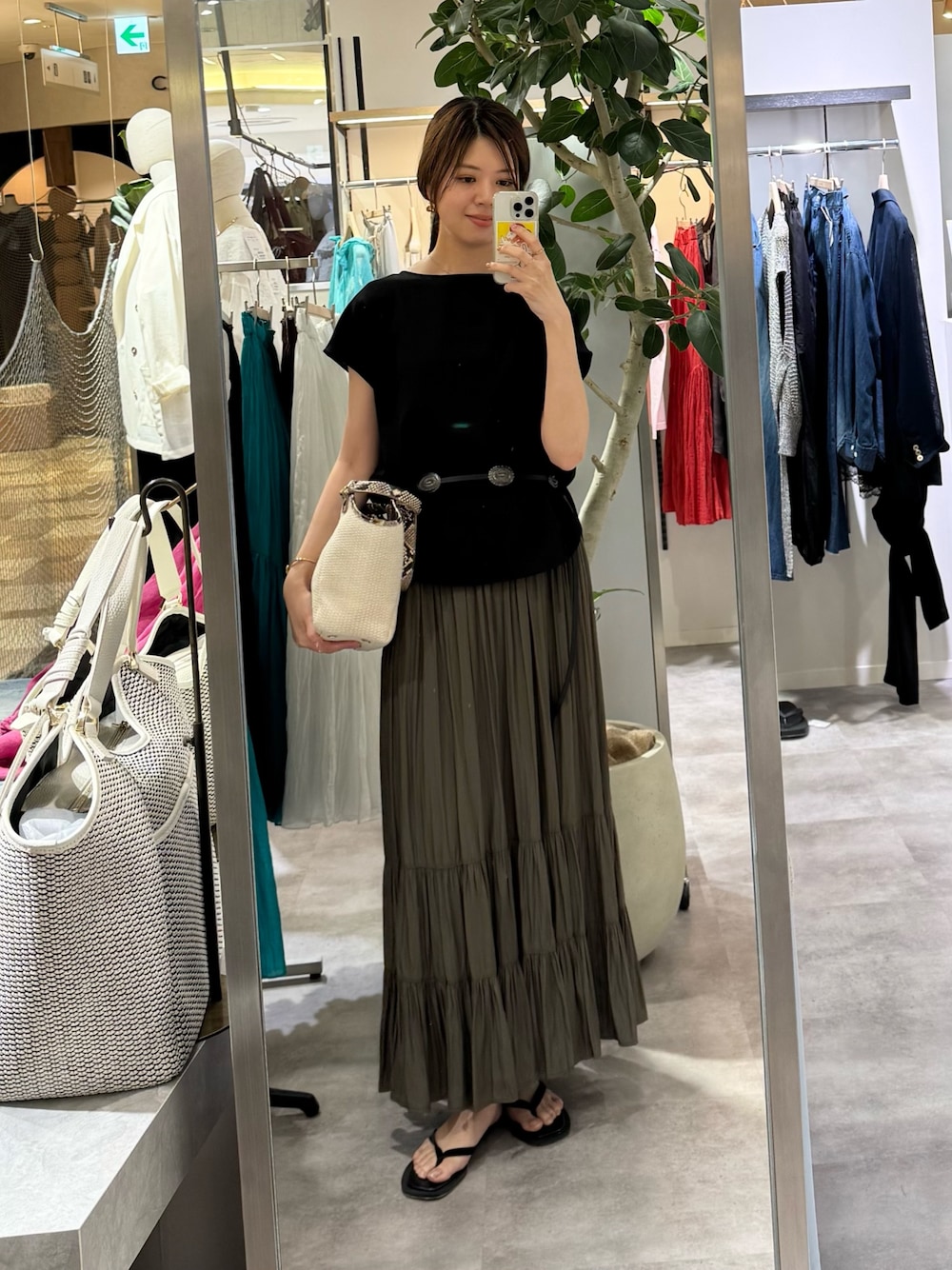 ブラック系のシャツ/ブラウス、ブラウン系のスカート、ベージュ系のハンドバッグを着用したレディースの夏コーディネートの1枚目の写真