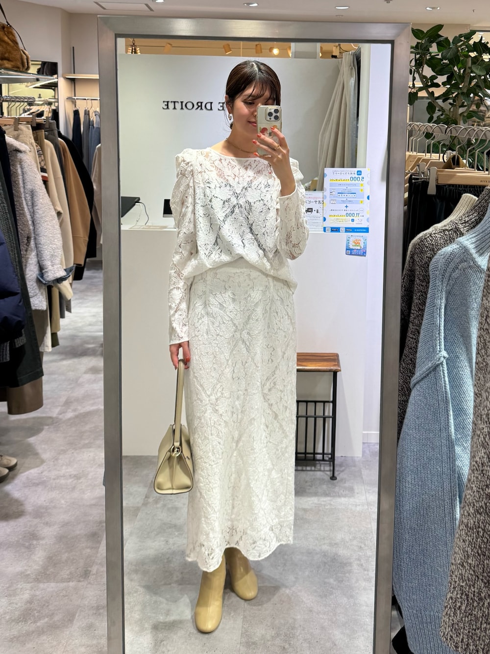 ホワイト系のシャツ/ブラウス、ホワイト系のスカート、ベージュ系のハンドバッグを着用したレディースの冬コーディネートの1枚目の写真