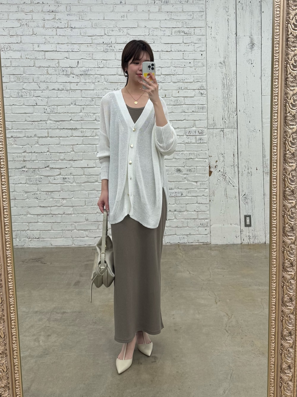 ブラウン系のワンピース、ゴールド系のショルダーバッグ、ホワイト系のカーディガン/ボレロを着用したレディースの春コーディネートの1枚目の写真
