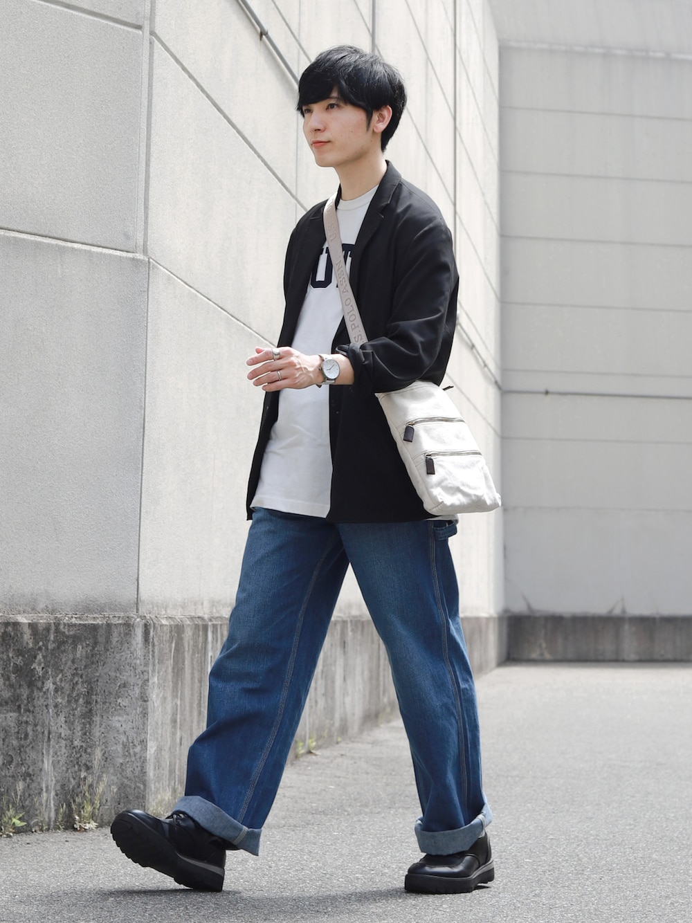 ブルー系のデニムパンツ、ブラック系のドレスシューズ、ホワイト系のショルダーバッグを着用したメンズの春コーディネートの1枚目の写真