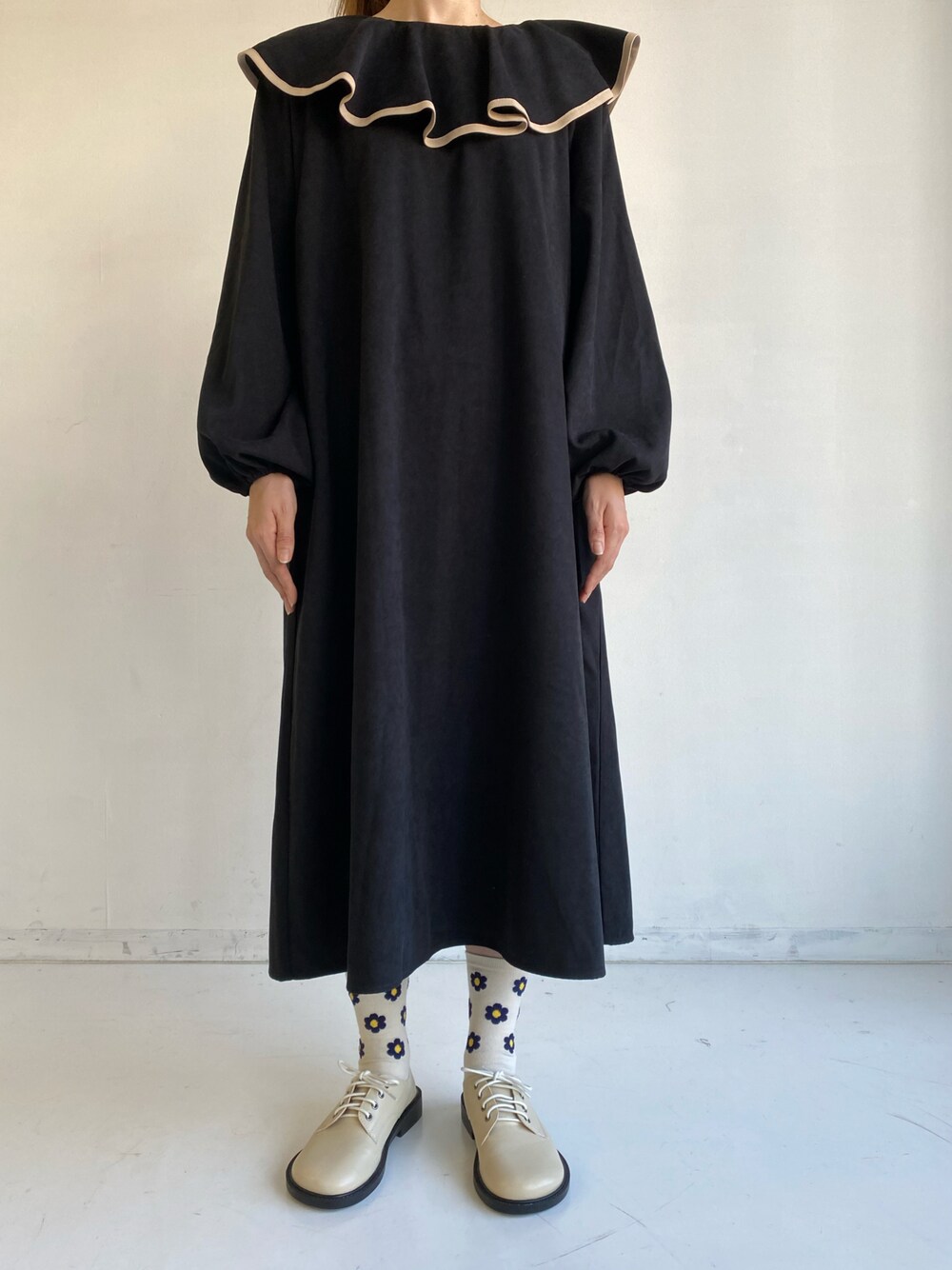 ブラック系のワンピースを着用したレディースの秋コーディネートの1枚目の写真