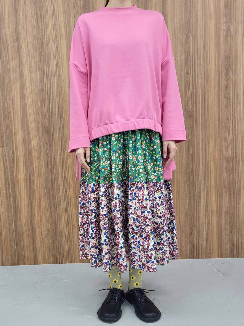 ピンク系のスウェット、グリーン系のスカートを着用したレディースの冬コーディネートの1枚目の写真