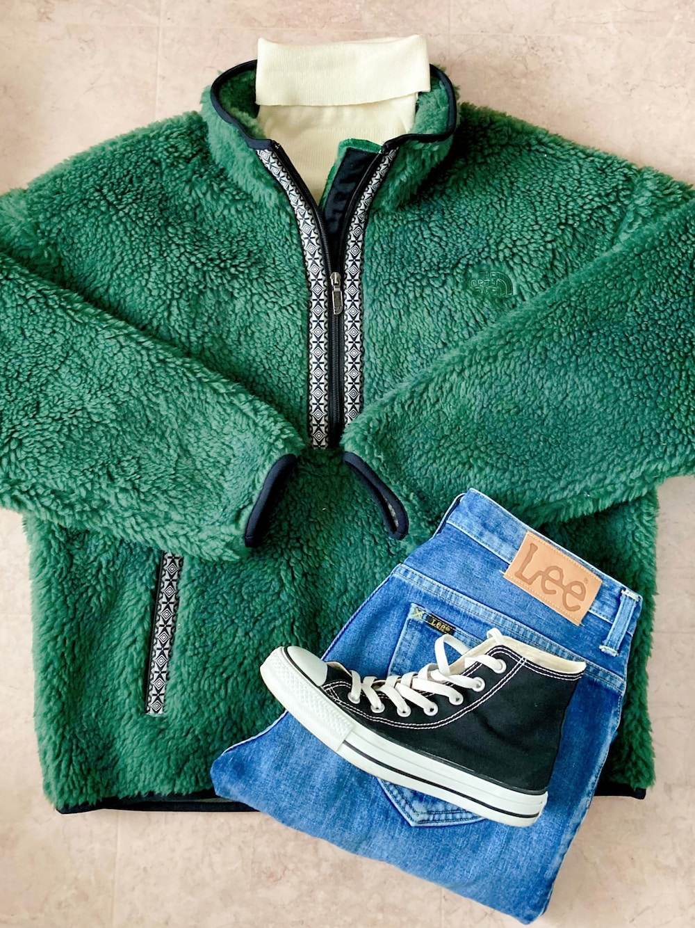 ブラック系のスニーカー、ブルー系のデニムパンツ、グリーン系のその他アウターを着用したレディースの冬コーディネートの1枚目の写真