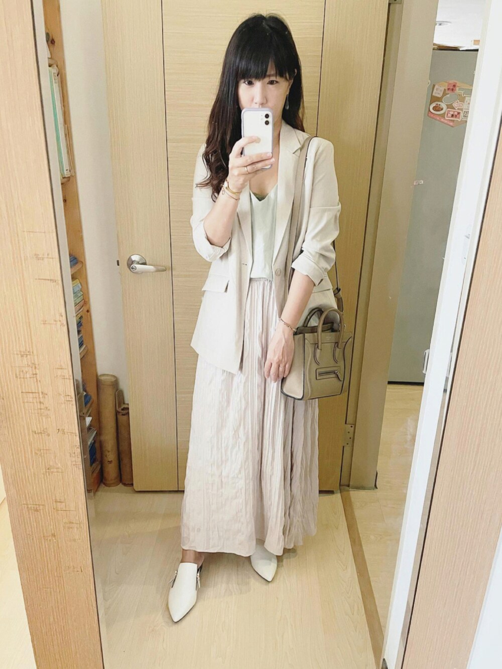 グリーン系のテーラードジャケット、ベージュ系のバッグ、ホワイト系のシューズを着用したレディースの秋コーディネートの1枚目の写真