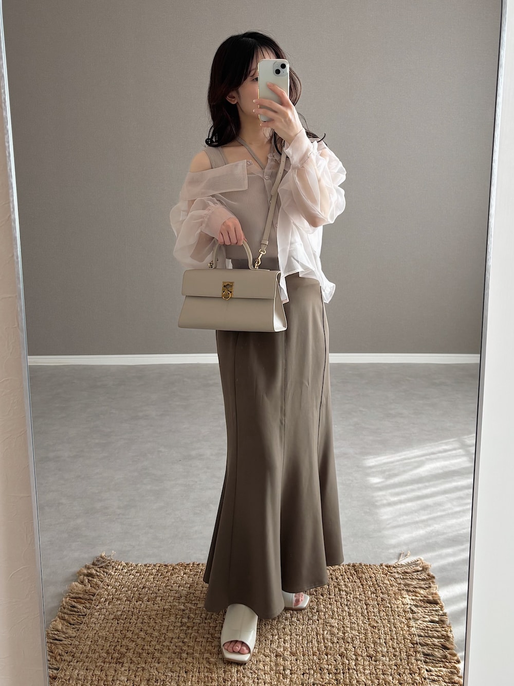ベージュ系のバッグ、ブラウン系のスカート、ホワイト系のサンダルを着用したレディースの春コーディネートの1枚目の写真