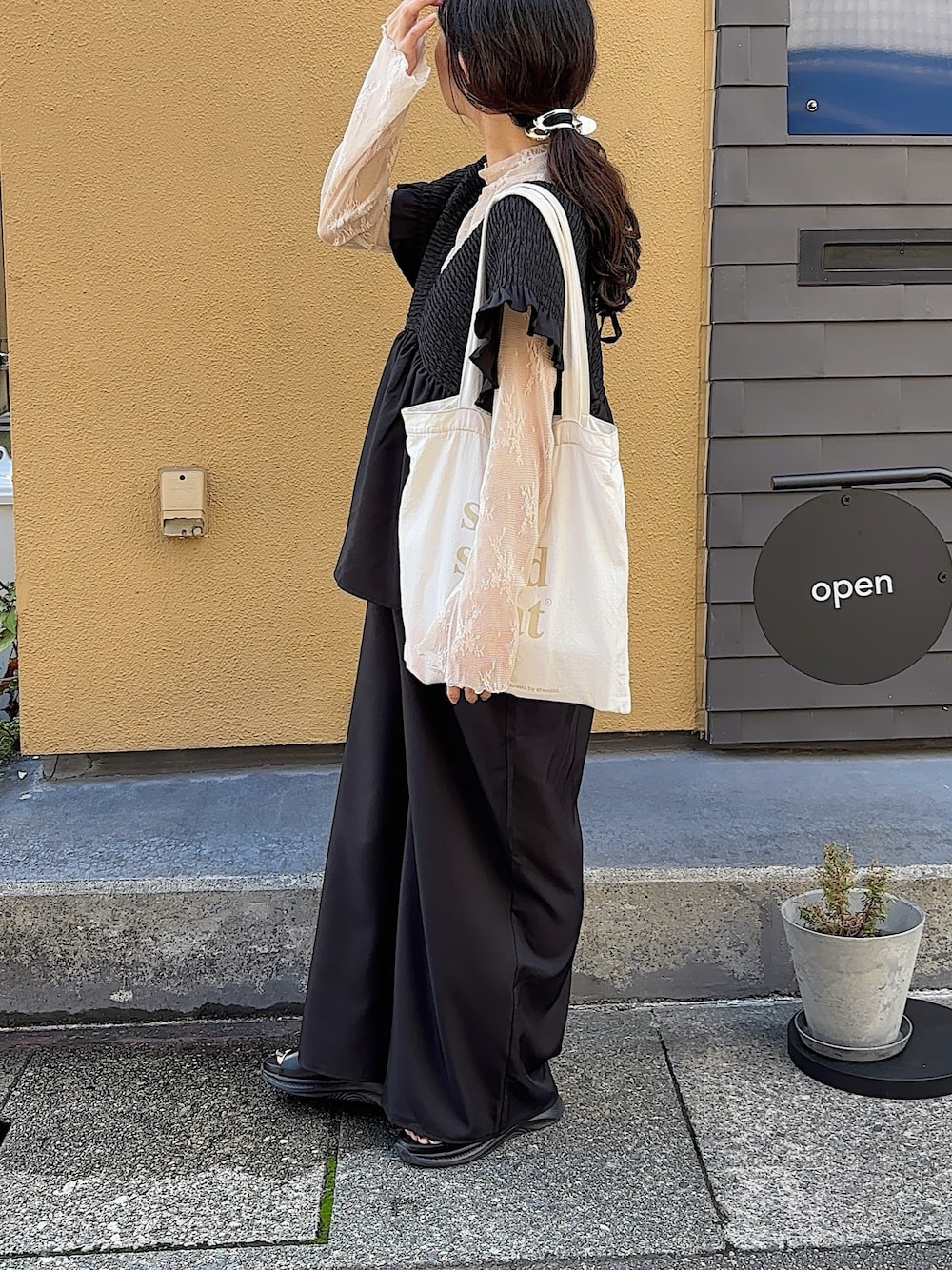 ホワイト系のTシャツ/カットソー、ブラック系のオールインワン・サロペット、ホワイト系のトートバッグを着用したレディースの秋コーディネートの1枚目の写真